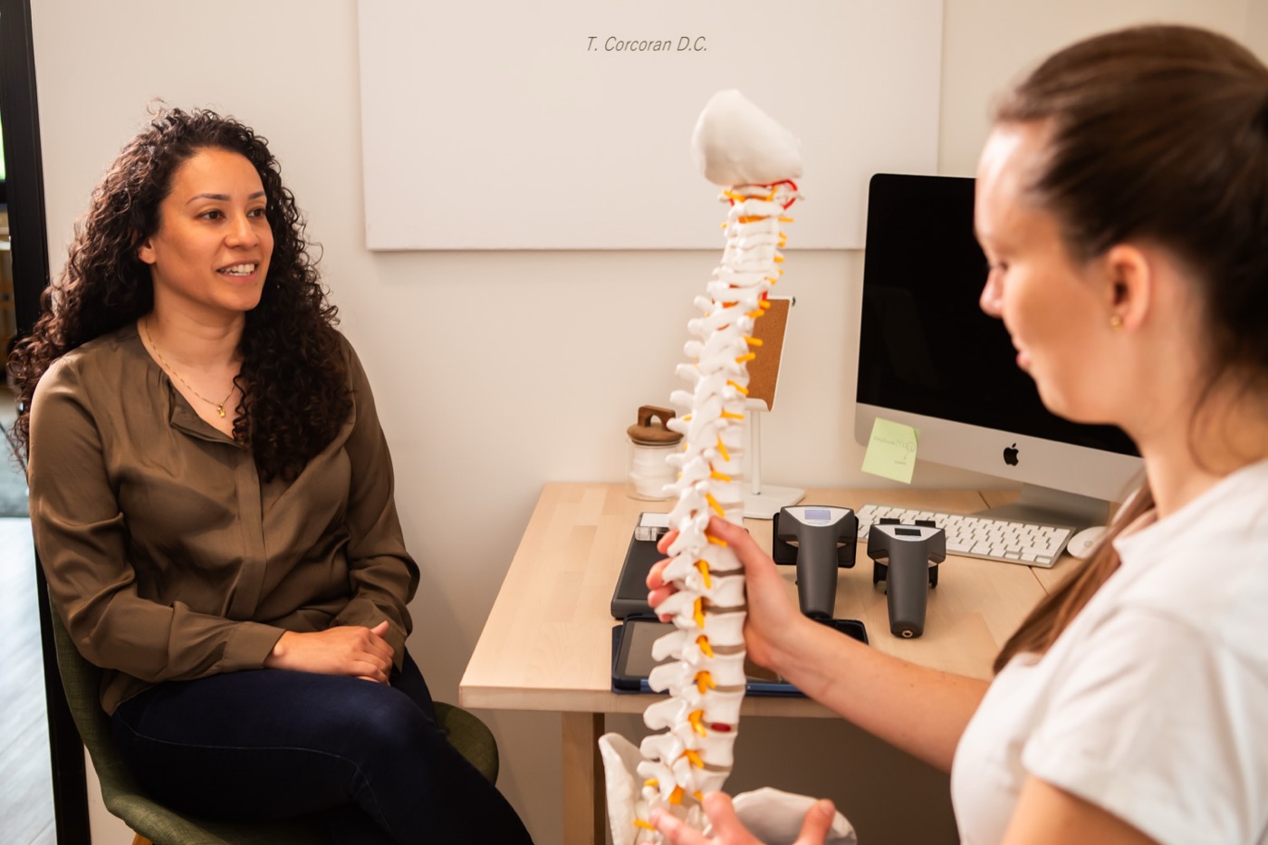 Chiropractor legt met een wervelkolommodel uit wat de scan laat zien bij TOPCHIRO Maastricht